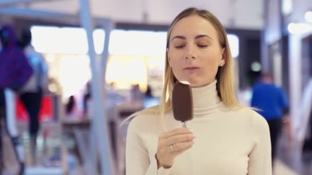 Portret van een jonge vrouw die ijs eet — Stockvideo