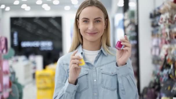 Emozionale giovane donna tiene lo smalto in serbo e guarda nella fotocamera — Video Stock