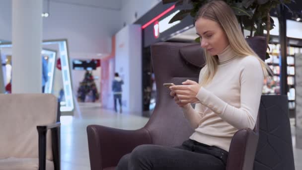 Mujer uso del teléfono móvil en el centro comercial — Vídeos de Stock