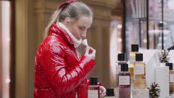 Feliz hermosa mujer probando perfumes en la tienda de cosméticos — Vídeos de Stock