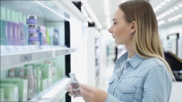 La mujer elige el perfume en la tienda — Vídeo de stock