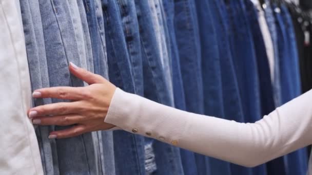 Mujer en ropa casual elige jeans . — Vídeos de Stock