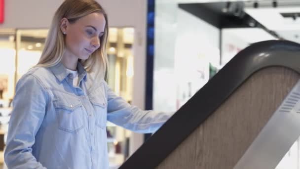 Mujer usando información de pantalla táctil de computadora en la tienda — Vídeos de Stock