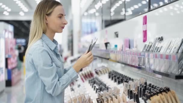 女人在商店里挑化妆品刷 — 图库视频影像