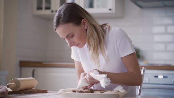 Mujer decoración al horno de pan de jengibre galletas de Navidad. Las manos femeninas glaseado y glaseado fresco panadería de vacaciones. Comida festiva, familia, Navidad y Año Nuevo concepto de tradiciones . — Vídeos de Stock