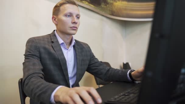 Portret młodego mężczyzny siedzącego przy biurku w biurze — Wideo stockowe