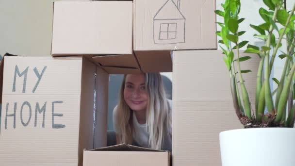 Woman relaxing and laughing after unpacking cartons from house move. Moving to a new apartment concept — Stock Video