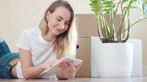 Frau richtet neue Wohnung mit digitalem Tablet ein — Stockvideo