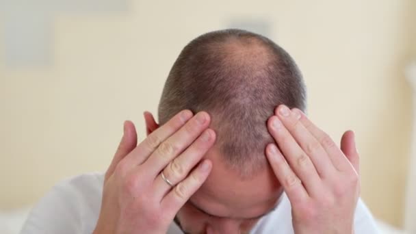 Людська алопеція або випадання волосся - рука дорослого чоловіка вказує на лисину — стокове відео