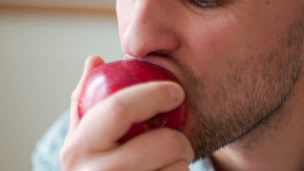 Primer plano retrato de boca masculina comiendo manzana roja — Vídeos de Stock