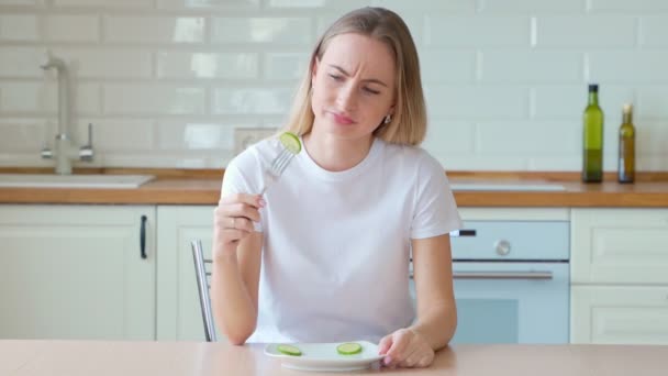 Mujer dieta deprimida come pepino en un plato — Vídeo de stock