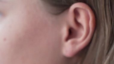 Müzik dinlemek için kulağına kulaklık takan ve müziğin ritmiyle dans eden bir kadın.