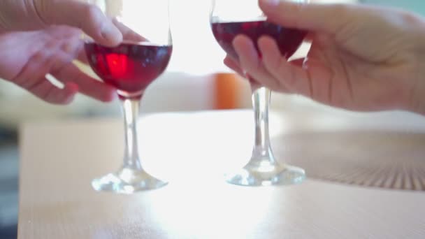 Kadın ve erkek el çırpma kadehi kırmızı şarap yıldönümünü kutluyor.. — Stok video