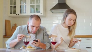 Kahvaltı masasında cep telefonu kullanan bir çift.