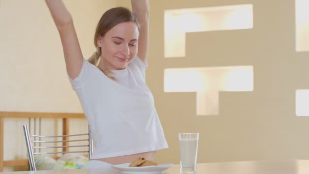 Mujer con vaso de leche y sabrosas galletas en casa — Vídeo de stock