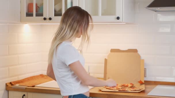 Feliz joven mujer comiendo rebanada de pizza caliente en casa — Vídeo de stock