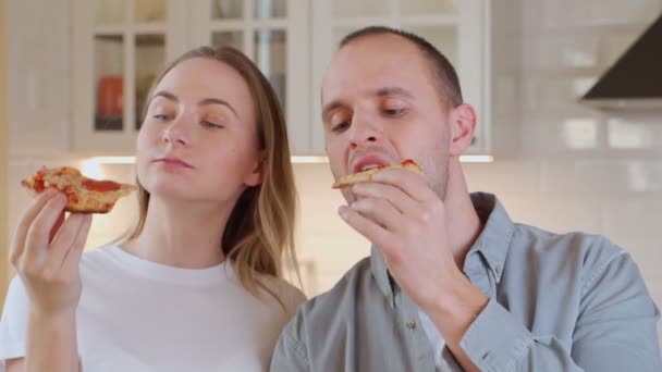 Casal gananciosamente comer pizza deliciosa, vício em fast food, comida não saudável — Vídeo de Stock