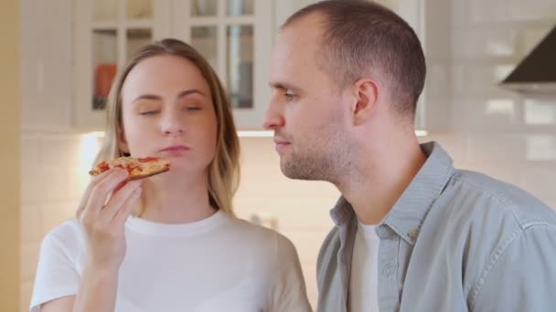 Una pareja joven está almorzando en el salón. Comer pizza — Vídeos de Stock