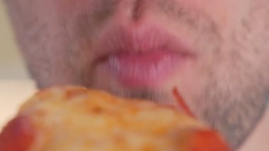 Yakın plan adam pizza yiyor, fast food yiyor.