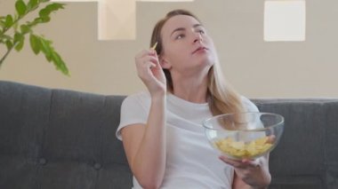 Kanepede patates cipsi yiyen kadın.