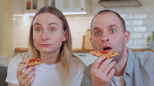夫妻放松，看电视和在家里吃披萨. — 图库视频影像
