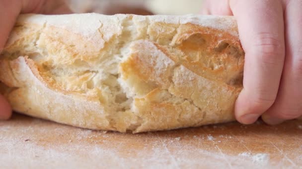 Zeitlupe der Hände, die einen frisch gebackenen Laib Brot brechen — Stockvideo