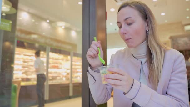 Leende kvinna äter färsk sallad på caféet — Stockvideo