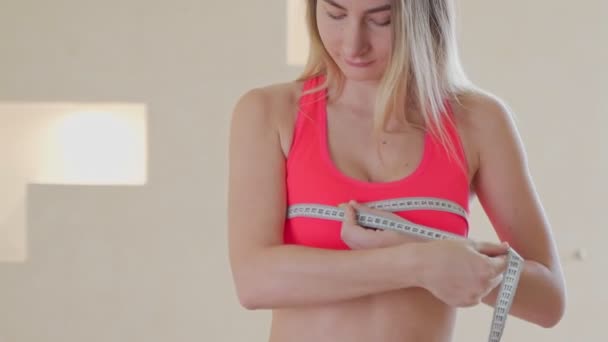 Dieet, gezondheid en beweging concept - mooie sportieve vrouw meten van haar borst — Stockvideo