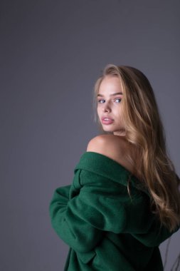 Uzun yeşil trençkotla poz veren muhteşem şık sarışın manken.