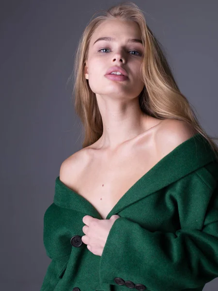 Wunderschönes stylisches blondes Model posiert im langen luxuriösen grünen Trenchcoat — Stockfoto