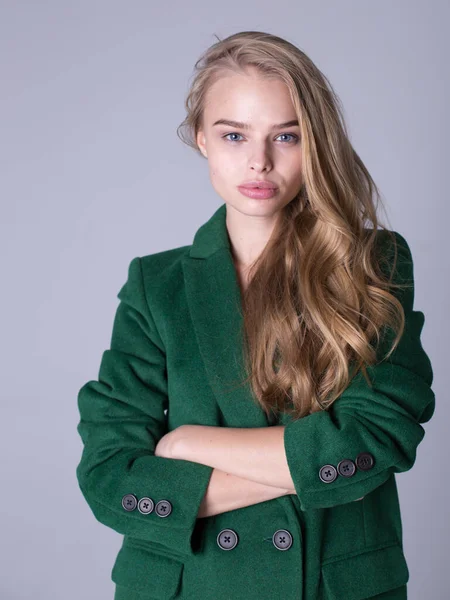 Das Bild einer attraktiven, eleganten Blondine im grünen Mantel — Stockfoto