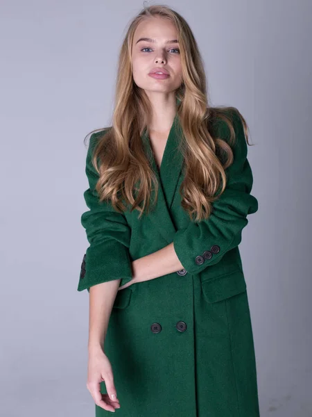 Un'immagine di una bionda attraente ed elegante con un cappotto verde — Foto Stock