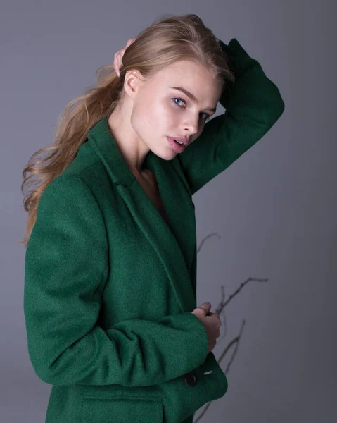 Wunderschönes stylisches blondes Model posiert im langen luxuriösen grünen Trenchcoat — Stockfoto
