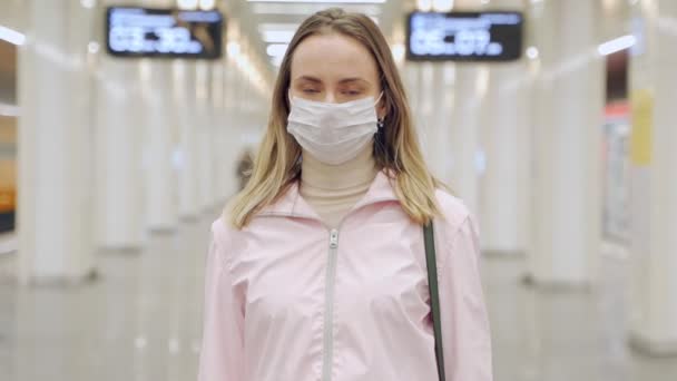 Женщина в защитной стерильной маске для лица смотрит на камеру на станции метро, вирус, концепцию пандемии коронавируса — стоковое видео