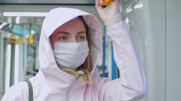 Kvinde med beskyttende maske på ansigtet sidder i undergrundsbanen bil, ser bekymret. Forebyggende foranstaltninger på offentlige steder i epidemiske regioner . – Stock-video