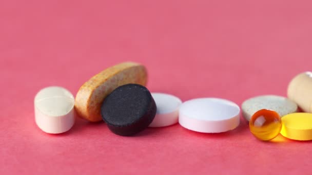 Comprimidos, vitaminas, medicamentos, óleo de peixe ômega-3, cápsulas de gel, medicamentos e suplementos nutricionais para cuidados de saúde. Fundo rosa . — Vídeo de Stock
