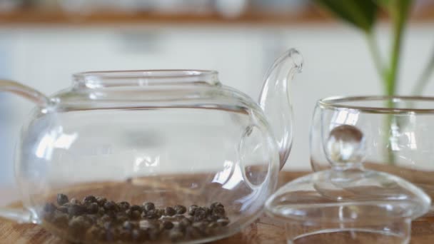 A zöld tea átlátszó üveg teáskannában történő főzésének módszere — Stock videók