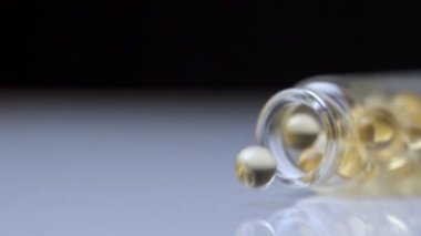 Masaya balık yağı kapsülleri döküyorum. Yavaş Hareket