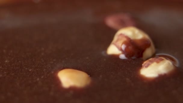 Las avellanas caen en las olas de baño de chocolate en cámara lenta — Vídeos de Stock