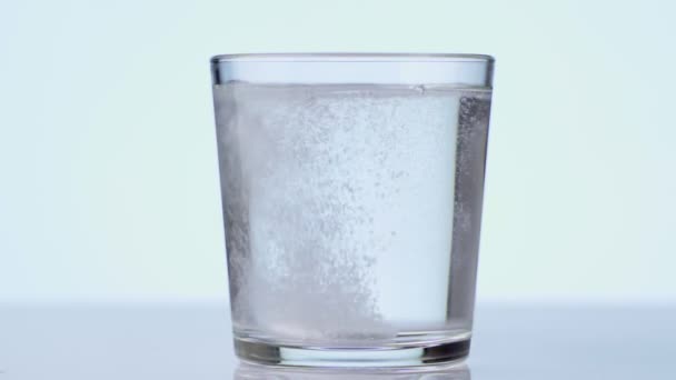 Tabletta leesik az üvegbe vízzel. pezsgőtabletta aszpirin. közelkép fehér háttér — Stock videók