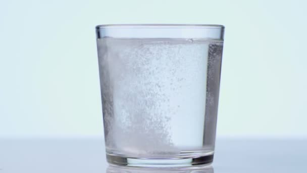 Pilule tombant dans le verre avec de l'eau. comprimé effervescent aspirine. gros plan sur fond blanc 