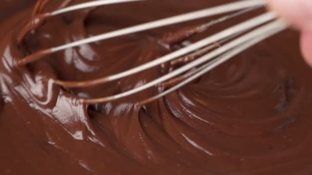 Mixing melted liquid chocolate with a whisk. Close up of liquid hot chocolate swirl. — Stock Video