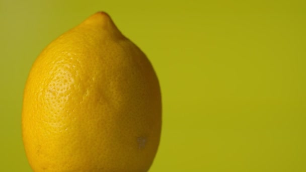 黄色いレモンの回転360度。黄色の背景 — ストック動画