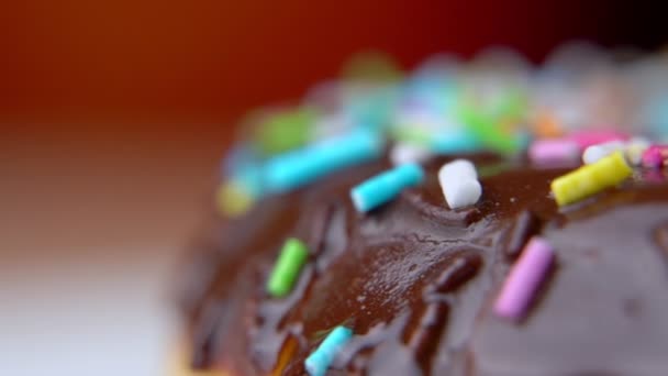 Νόστιμο γλυκό ντόνατ περιστρέφεται σε ένα πιάτο. Donut γκρο πλαν μακρο πλαν γυρισμα — Αρχείο Βίντεο