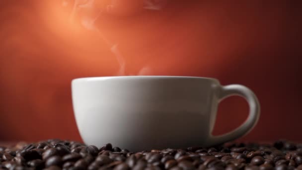Вид сбоку на белую чашку черного кофе на кофейных бобах — стоковое видео