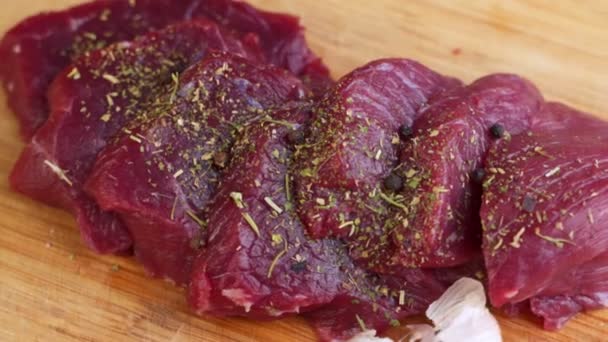 Świeże surowe mięso wołowe z pieprzem gotowe do grillowania, obracające się — Wideo stockowe