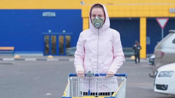 En maskerad kvinna med en matvagn på gatan. — Stockvideo