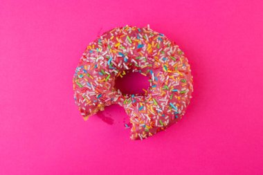 Lezzetli ısırılmış tatlı çörek. Yukarıdan manzara. Parlak ve renkli serpiştirilmiş donut yakın çekim makro fotoğraf..