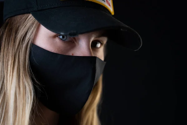 A girl with a protective black mask on her face to protect her from the coronavirus. Coronavirus pandemic,covid-2019.Chinese outbreak of coronavirus.