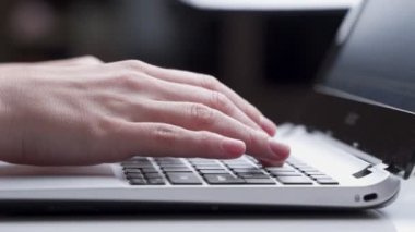 Dizüstü bilgisayarda çalışmak, klavyede yazmak, modern ofis işleri. Klavyede kadın eli izi var. Yakın plan..